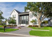 Elegant two-story home showcasing a well-maintained lawn and modern gray and white design elements at 2902 S Beach Dr, Tampa, FL 33629
