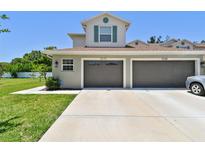 Charming townhouse featuring a two-car garage, manicured lawn, and neutral exterior paint, ideal for comfortable living at 5270 Neil Dr, St Petersburg, FL 33714