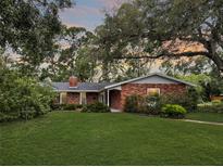 Charming brick home with a well-manicured front lawn and mature trees at 5901 3Rd S St, St Petersburg, FL 33705