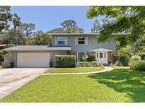Charming two-story home with a well-manicured lawn, lush landscaping, and an attached two-car garage at 768 Pinellas Point S Dr, St Petersburg, FL 33705