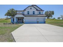Charming two-story home featuring a three-car garage and stone accents at 10517 Crestview Heights Ave, Thonotosassa, FL 33592