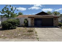Home exterior showing stonework and arched gate with attached two car garage at 11430 Nature Trl, Port Richey, FL 34668