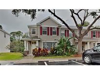 Charming townhome featuring red shutters, tasteful landscaping, and a welcoming entrance at 13640 Forest Lake Dr, Largo, FL 33771