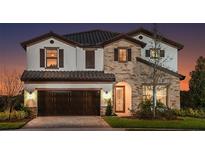 Elegant two-story home featuring stone accents, a tile roof, and a charming arched entryway and a 2-car garage at 13722 Heartwood Way, Parrish, FL 34219