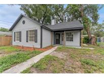 Charming home exterior with gray siding, black trim, and well-maintained landscaping at 2313 Palm Ave, Seffner, FL 33584