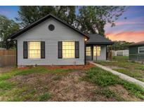 Charming single-story home with gray siding, black shutters, and lush green landscaping at 2313 Palm Ave, Seffner, FL 33584