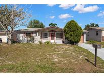 Charming single-story home features a well-manicured lawn and inviting front porch at 3348 Clydesdale Dr, Holiday, FL 34691