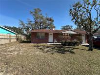 Charming single-story brick home with a well-maintained lawn and mature trees under a bright blue sky at 4419 Atwood Dr, Tampa, FL 33610