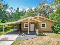 Charming single-story home with a covered carport and front porch with stylish railing detail at 473 Forest Ave, Brooksville, FL 34601