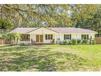 Charming single-story home with a well-manicured lawn and mature trees providing ample shade at 4805 E Regnas Ave, Tampa, FL 33617