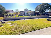 Cozy single-story home featuring a well-maintained lawn and decorative fence at 4812 Bonita Vista Dr, Tampa, FL 33634