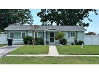 Charming single-story home with well-manicured lawn, mature trees, and sidewalk to the front door at 5340 Denver Ne St, St Petersburg, FL 33703