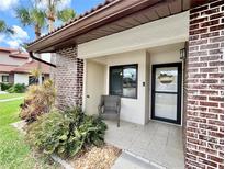 Inviting front porch with tile flooring, accent brick and chair at 7360 Ulmerton Rd # 16A, Largo, FL 33771