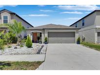 Charming single-story home with a two-car garage and well-manicured landscaping at 872 Olive Conch St, Ruskin, FL 33570
