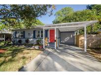 Charming single-story home featuring a bright red front door and covered carport at 9025 1St Ne St, St Petersburg, FL 33702