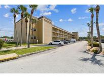 Condominium complex with neutral stucco, balconies, well-maintained landscaping, parking and palm trees at 1 Boca Ciega Point Blvd # 310, St Petersburg, FL 33708