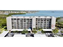 Waterfront condo building with covered parking and lush landscaping at 1332 Pasadena S Ave # 208, South Pasadena, FL 33707