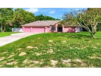 Charming single-story home with a well-manicured lawn, mature trees, and inviting curb appeal at 14273 Nugent Circle, Spring Hill, FL 34609