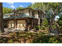Charming townhouse with a brick facade, attached garage, and lush landscaping at 2665 Sequoia Ter # 306, Palm Harbor, FL 34683