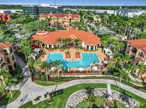 Stunning aerial view of a resort-style pool with lush landscaping and vibrant orange roofs at 2724 Via Murano # 615, Clearwater, FL 33764