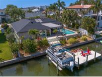 Beautiful waterfront home featuring a private boat dock, swimming pool, and lush landscaping at 2817 Seabreeze S Dr, Gulfport, FL 33707