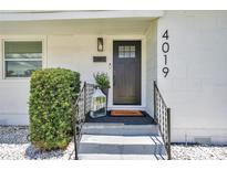 Charming front door with black hardware, a welcome mat, and decorative plants at 4019 W Bay To Bay Blvd, Tampa, FL 33629