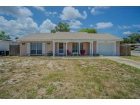 Charming single-story home with a covered front porch and attached one-car garage, surrounded by a lawn at 4150 Woodsville Dr, New Port Richey, FL 34652