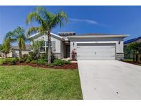Charming single-story home with a well-manicured lawn, palm trees, and a two-car garage at 5920 Silver Palm Blvd, Bradenton, FL 34211