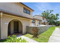 Inviting townhome exterior featuring a stucco facade, arched entry, and well-maintained landscaping at 6262 142Nd N Ave # 607, Clearwater, FL 33760