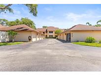 Well-maintained exterior of townhomes with individual garages in a quiet residential community, under a blue sky at 8103 Bardmoor Pl # 203G, Seminole, FL 33777
