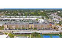 Aerial view showcases a waterfront condo building with boat docks, parking, tennis courts and a pool at 1 Boca Ciega Point Blvd # 215, St Petersburg, FL 33708