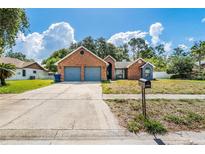 Charming single-Gathering home with a brick facade, two-car garage, and a well-maintained front yard at 1024 Dockside Dr, Lutz, FL 33559