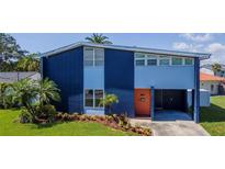 Modern two-story home showcasing a colorful exterior, a manicured lawn, and vibrant landscaping at 111 Chesapeake Ave, Tampa, FL 33606