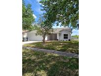 Charming single-story home boasts a manicured front yard and attached two-car garage, perfect for suburban living at 12910 Longcrest Dr, Riverview, FL 33579