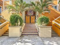 Stairs with decorative tiles leading to a secured condo entrance, flanked by planters and palm trees at 200 4Th S Ave # 229, St Petersburg, FL 33701