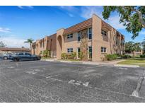 Exterior of a charming two-story condo building showing parking, landscaping and stone details at 224 Aspen Cir # 224, Seminole, FL 33777