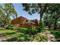 Exterior view of a townhome with a well-kept lawn, a fence and beautiful trees at 2706 11Th Ct, Palm Harbor, FL 34684