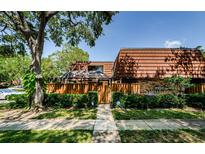 Charming townhome exterior with a wooden fence, tile roof, and lush landscaping at 2706 11Th Ct, Palm Harbor, FL 34684