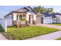 Charming single-story home featuring a well-manicured lawn and a private driveway leading to an attached garage at 3002 W Abdella St, Tampa, FL 33607