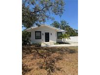 Charming bungalow with modern black trim, crisp white paint, a new door and landscaped with small palms at 3008 E 38Th Ave, Tampa, FL 33610