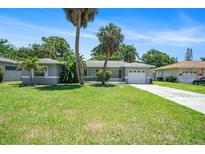 Charming single-story home with well-maintained lawn, palm trees, and an attached one car garage at 105 N Comet Ave, Clearwater, FL 33765