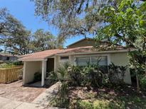 Charming single-story home featuring mature trees, lush landscaping and a covered front entryway at 14725 Morning Dr, Lutz, FL 33559