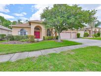 Charming one-story home with a well-manicured lawn, mature trees, and a three-car garage at 18444 Eastwyck Dr, Tampa, FL 33647