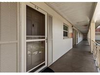 Hallway view of the condo entrance with unit number and beige exterior wall at 19029 Us Highway 19 N # 5-16, Clearwater, FL 33764