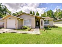 Charming single-story home with a well-manicured lawn and inviting front garden at 2818 Cedaridge Dr, Tampa, FL 33618