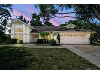 Charming single-story home featuring a two-car garage, manicured lawn, and beautiful twilight sky at 2901 50Th E Pl, Bradenton, FL 34203