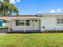 Home with front door framed by white columns and a charming garden and walkway at 302 Patty Dr, Oldsmar, FL 34677