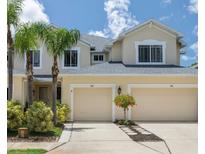 Inviting exterior featuring dual garages, manicured landscaping, and a well-maintained driveway at 542 Harbor Ridge Dr, Palm Harbor, FL 34683