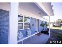 Inviting front porch featuring blue brick, white columns, and decorative chairs at 5608 Larimer Dr, Tampa, FL 33615