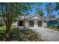 Charming single-story home featuring a well-manicured lawn and welcoming curb appeal with black framed garage doors at 5865 Meadowpark Pl, Lithia, FL 33547